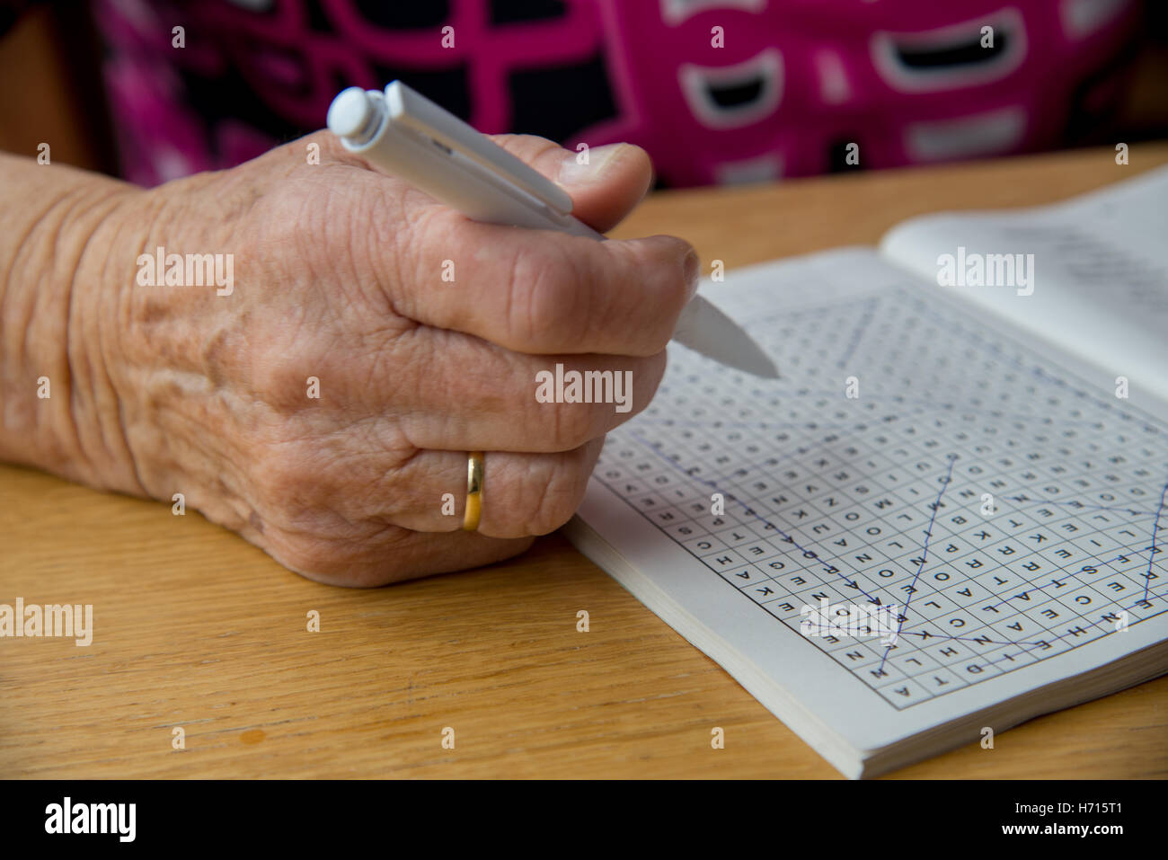 alte Frau am Tisch rätselhaft Stockfoto