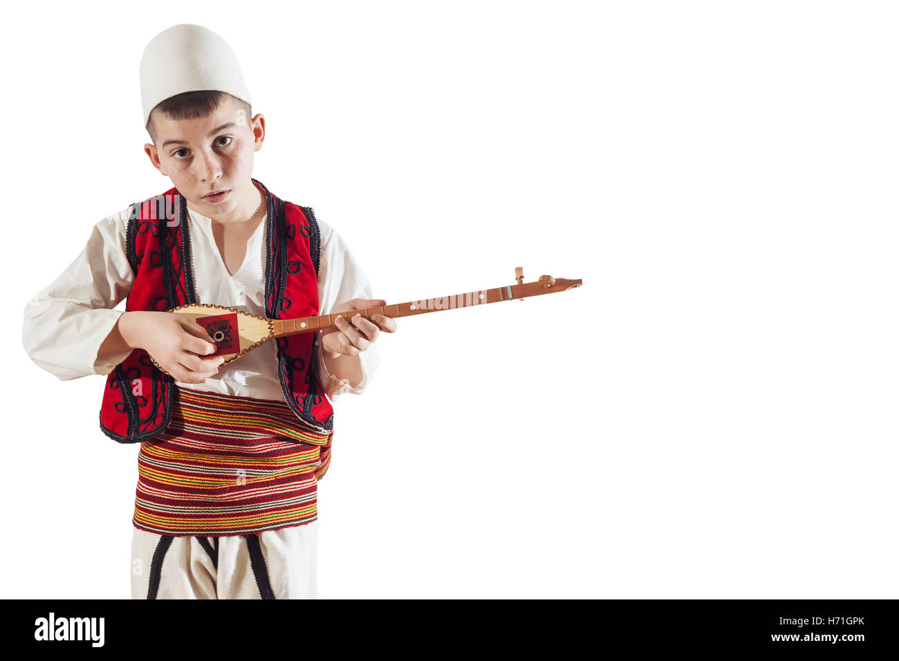 kleiner Junge in albanischer Tracht traditionelles Saiteninstrument zu spielen Stockfoto