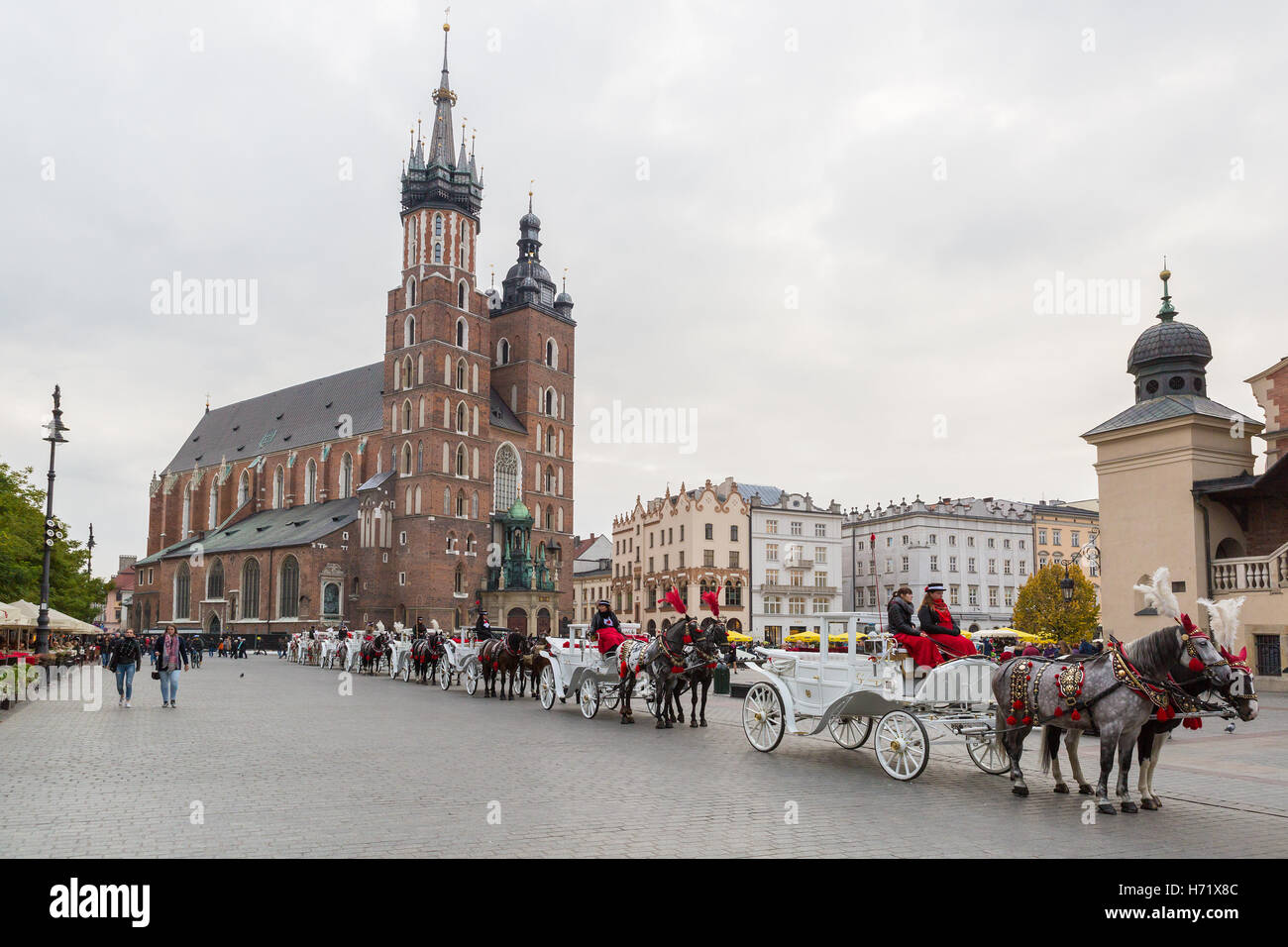 Krakau, Polen - 27. Oktober 2016: Traditionelle Pferdekutschen für Passagiere auf Krakauer Hauptmarkt in der Schlange warten. Stockfoto