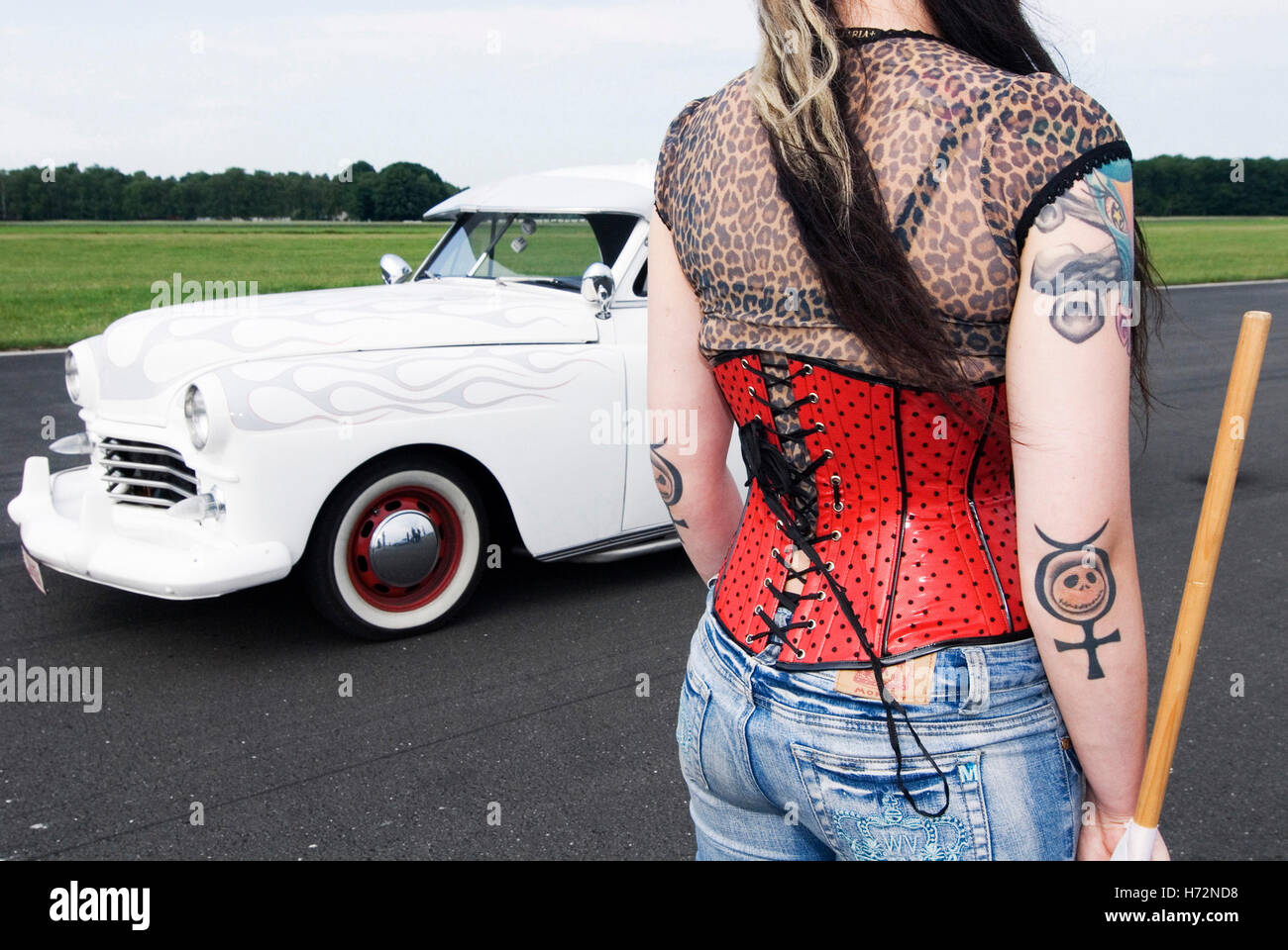 Starter-Mädchen mit einer roten Corsage und Tätowierungen neben eine weiße Limousine, Hot Rods, Kustoms, Kreuzer & Kunst an die "Bottrop Kustom Stockfoto
