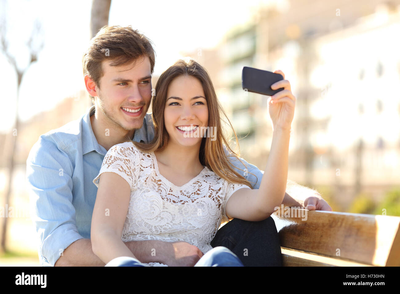 Paar Fotografieren ein Selbstporträt mit einem Smartphone in einem park Stockfoto