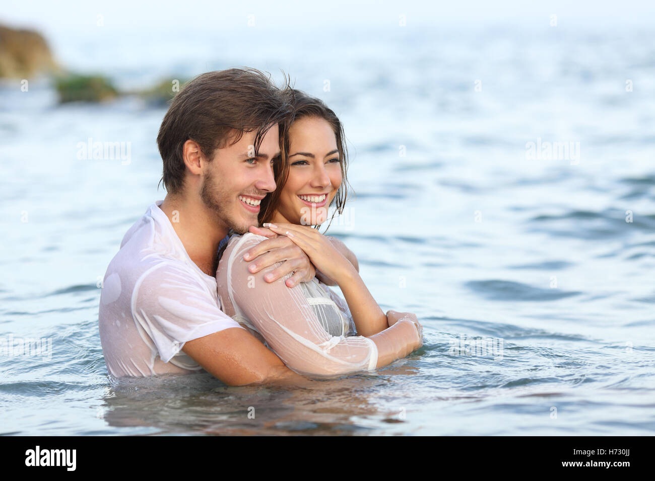Glückliches Paar in Liebe umarmt und Baden am Strand Stockfoto