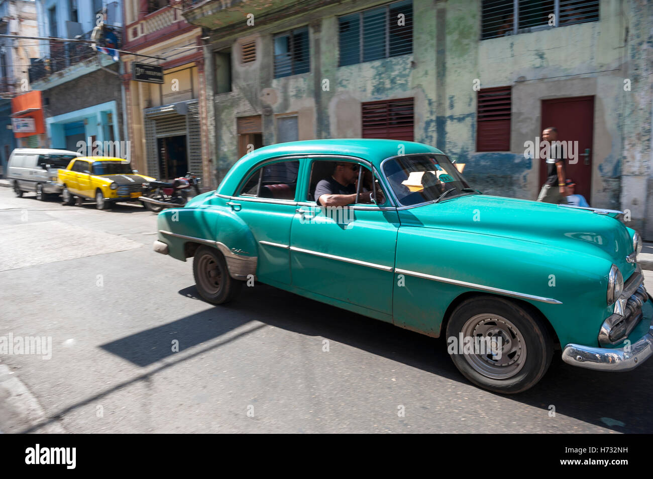 Havanna - 13. Juni 2011: Kubaner Fahrt in alten amerikanischen Autos Anteil Taxi vor typischen lokalen Architektur. Stockfoto