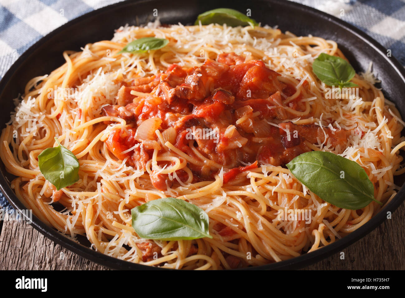 Spaghetti mit Nahaufnahme Amatriciana Soße auf einem Teller auf den Tisch. Horizontale Stockfoto