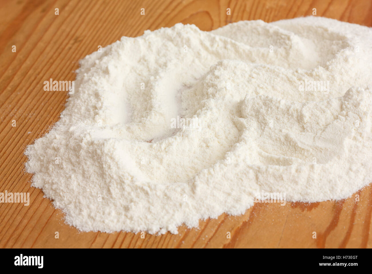 Weißes Mehl auf einem rustikalen alten Küche-Brett. Stockfoto