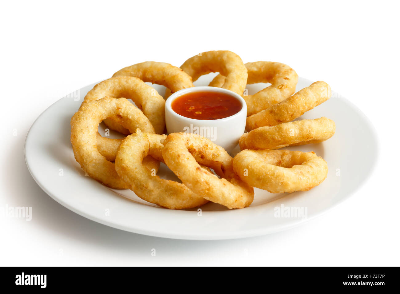 Haufen von tiefen gebratenen Zwiebeln oder Calamari Ringe mit Chili-Dip auf weißen Teller. Stockfoto