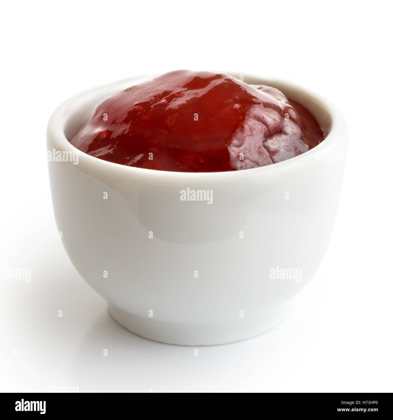 Kleine Töpfchen rote Erdbeermarmelade, isoliert auf weiss. In der Perspektive. Stockfoto
