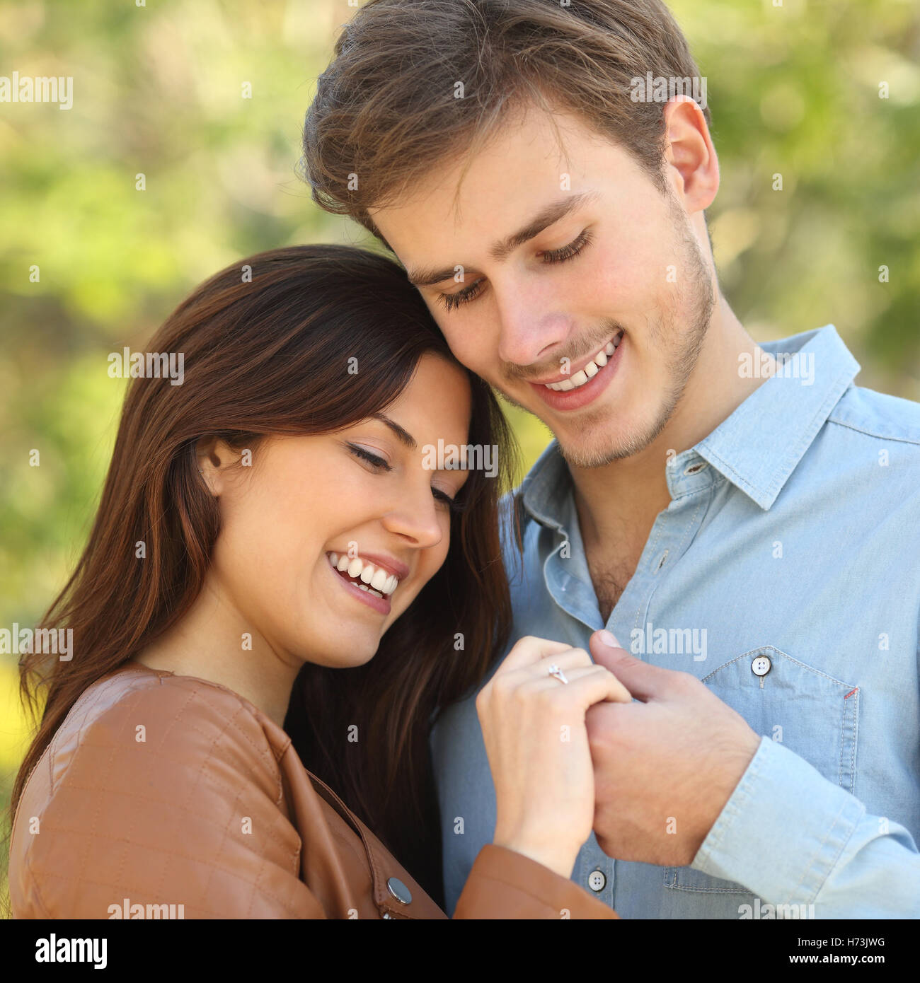 Paar umarmt und Hand in Hand und sieht einen Verlobungsring Stockfoto