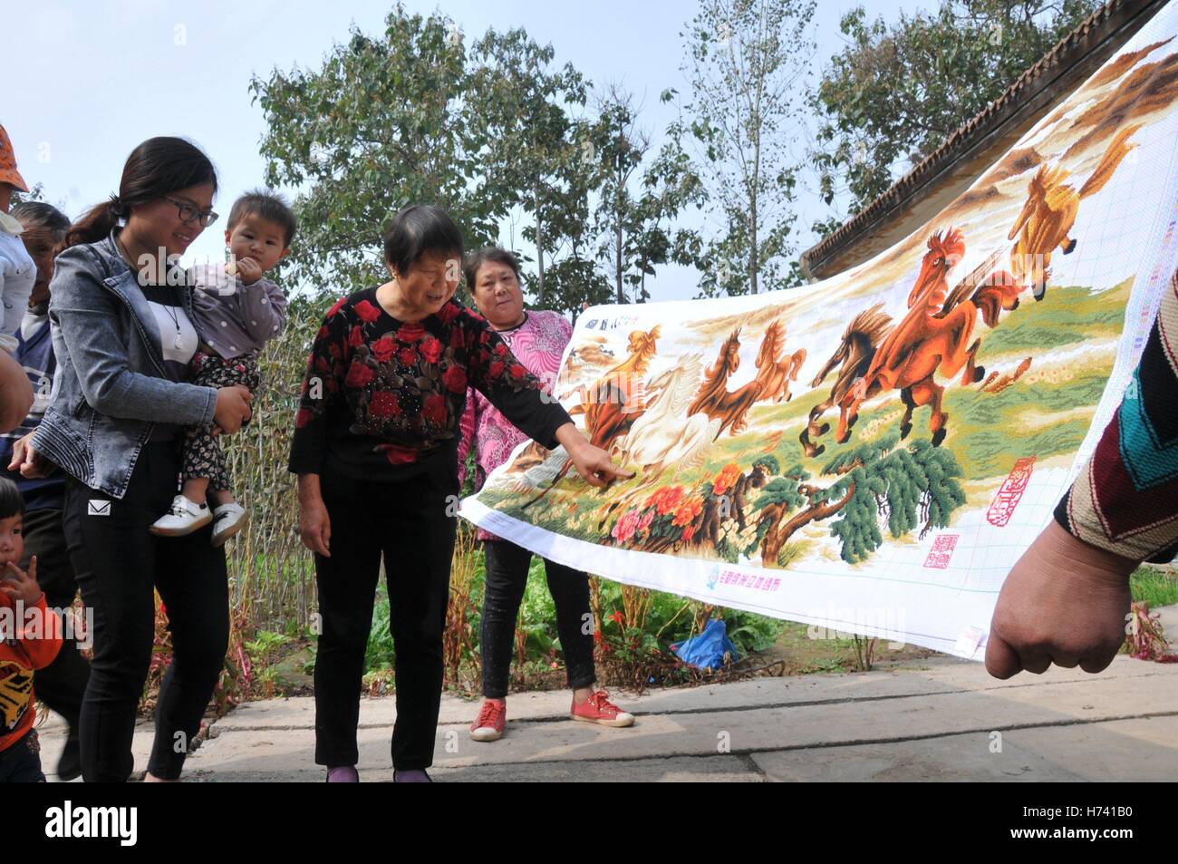 Anyang, Anyang, China. 24. Oktober 2016. Anyang, CHINA-24. Oktober 2016: (nur zur redaktionellen Verwendung. CHINA HERAUS). Chunfeng, eine 71 Jahre alte Frau, macht er Kreuzstich zu Hause Neihuang County, Anyang City, Zentral-China Henan Provinz, 24. Oktober 2016. Chunfeng begann vor etwa fünf Jahren zu Kreuzstich. Sie machte bereits Quersteppung "Qingming Riverside Landscape" und anderen traditionellen chinesischen Malerei. Der größte Kreuzstich gemacht indem er Chunfeng ist etwa 20 Meter lang. Kreuzstich ist eine beliebte Form der Stickerei gezählt-Thread in die x-förmige Stiche in einem gekachelten, raster Stockfoto