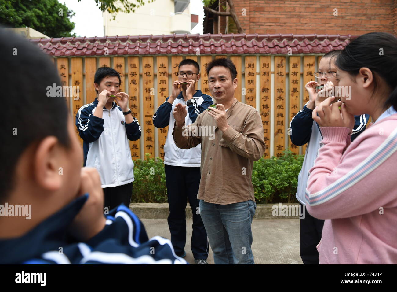 (161103)--FUZHOU, 3. November 2016 (Xinhua)--Qiu Shaochun vermittelt ein Blatt in einer Mittelschule in Fuzhou, Hauptstadt der Südosten Chinas Provinz Fujian, 2. November 2016 zu blasen. Setzen ein frisches Blatt auf den Lippen, bläst Qiu Shaochun eine Melodie nach der anderen, verzaubert das Publikum mit rhythmischen Vitalität und zarten Ausdruck. "Blätter der älteste, einfachste und bequemste Musikinstrument können" sagte Qiu, 51, der bekannteste Blatt weht Musiker in China. "Ich habe bisher in mehr als 30 Ländern durchgeführt." Qiu als Kind früher gerne hören blinde Fischer das Blatt Schlag und Stockfoto
