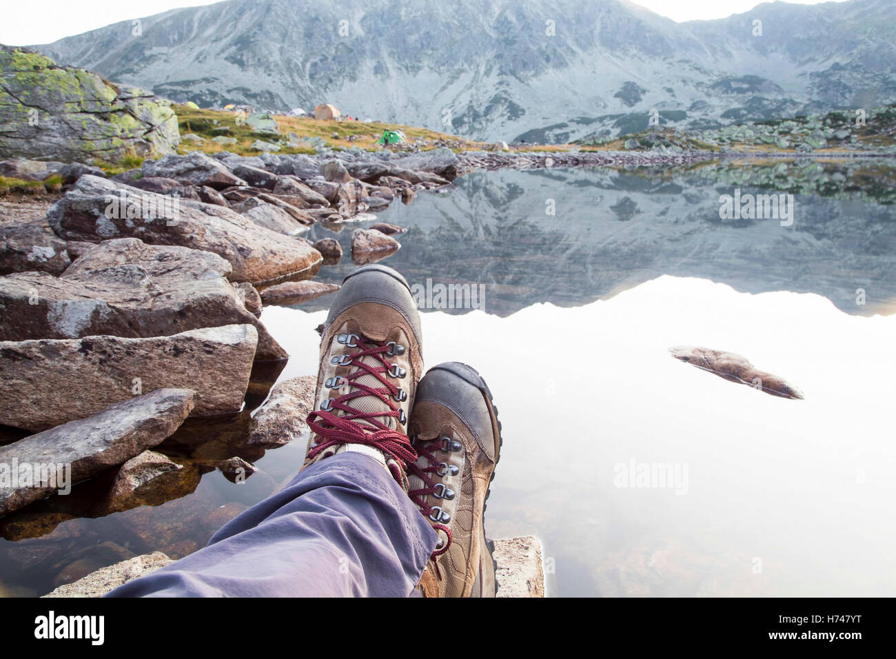 Hiking.Woman Beine mit Stiefeln und Berg malerischer See anzeigen Stockfoto