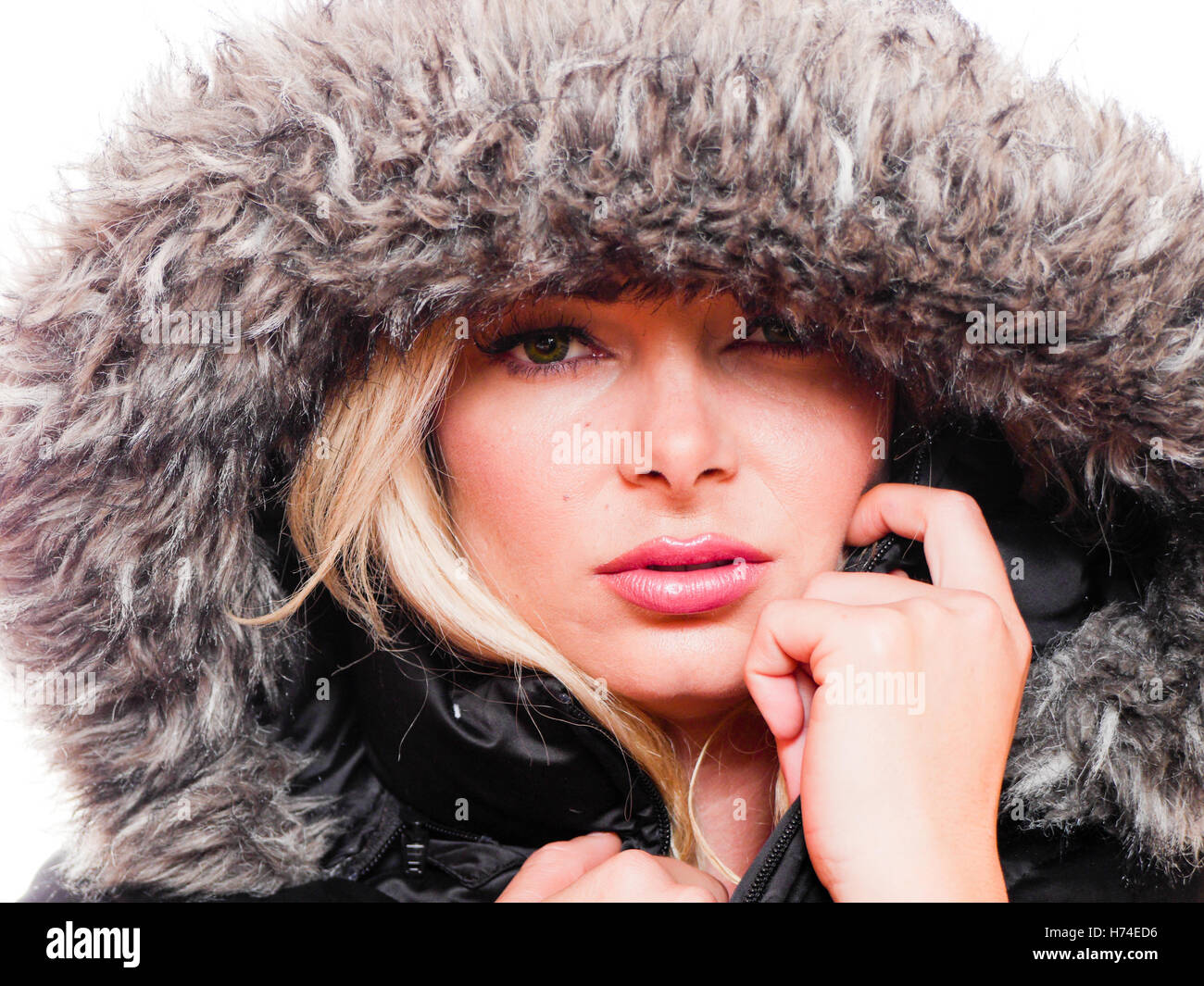 Closeup Portrait einer attraktiven kaukasischen Frau trägt einen Wintermantel mit der Haube nach oben gezogen. Stockfoto