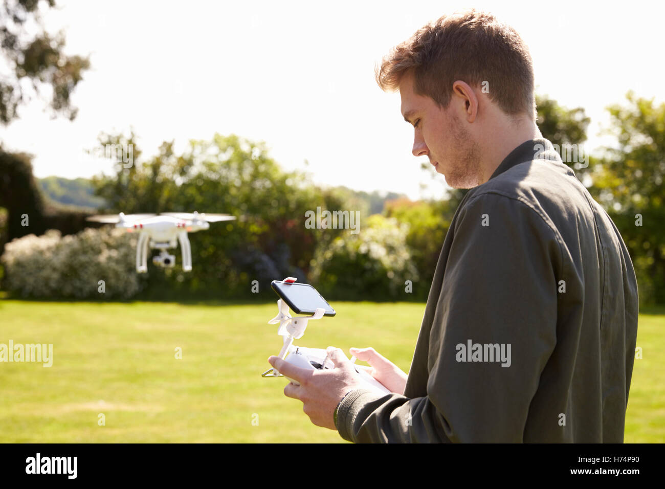 Mann fliegen Drone Quadcopter im Garten Stockfoto