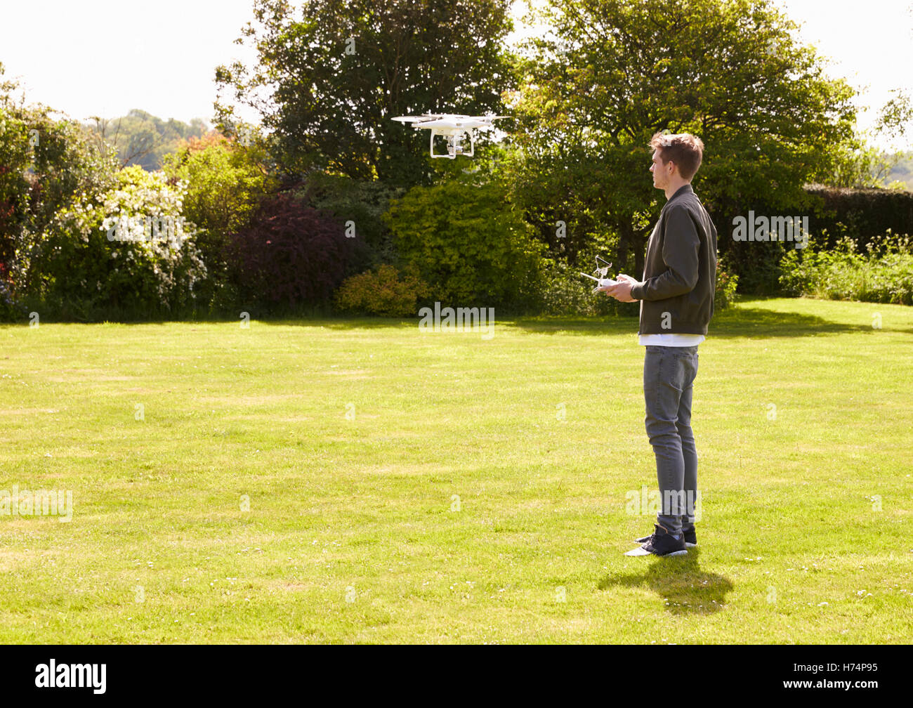 Mann fliegen Drone Quadcopter im Garten Stockfoto