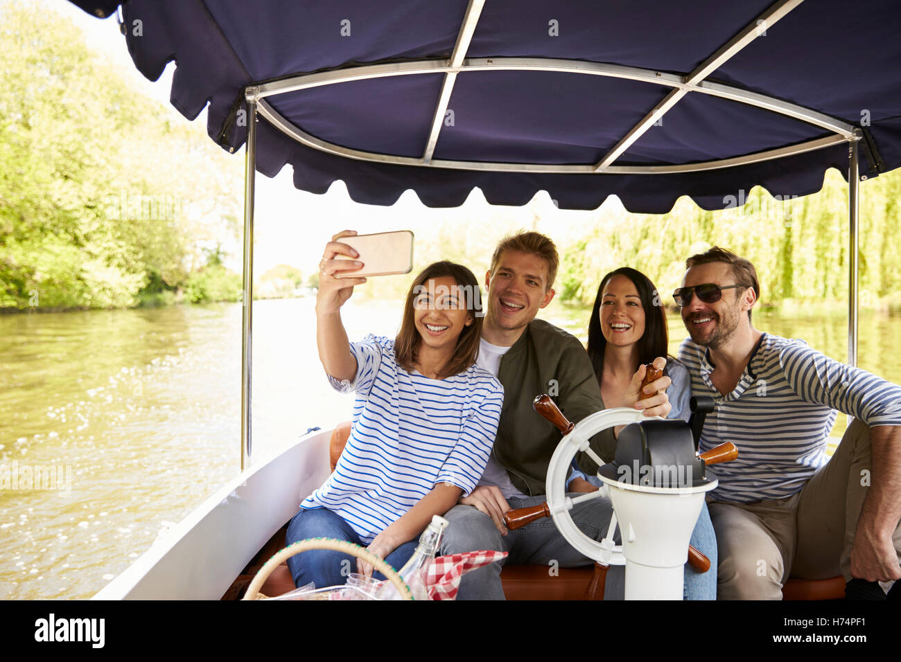 Freunde nehmen Selfie während Boot fahren am Fluss zusammen Stockfoto