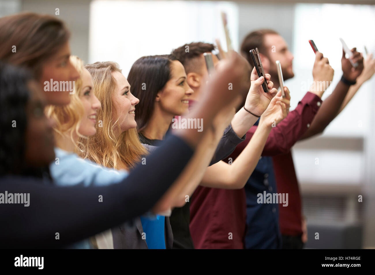 Reihe von Studenten der Universität fotografieren mit smartphones Stockfoto