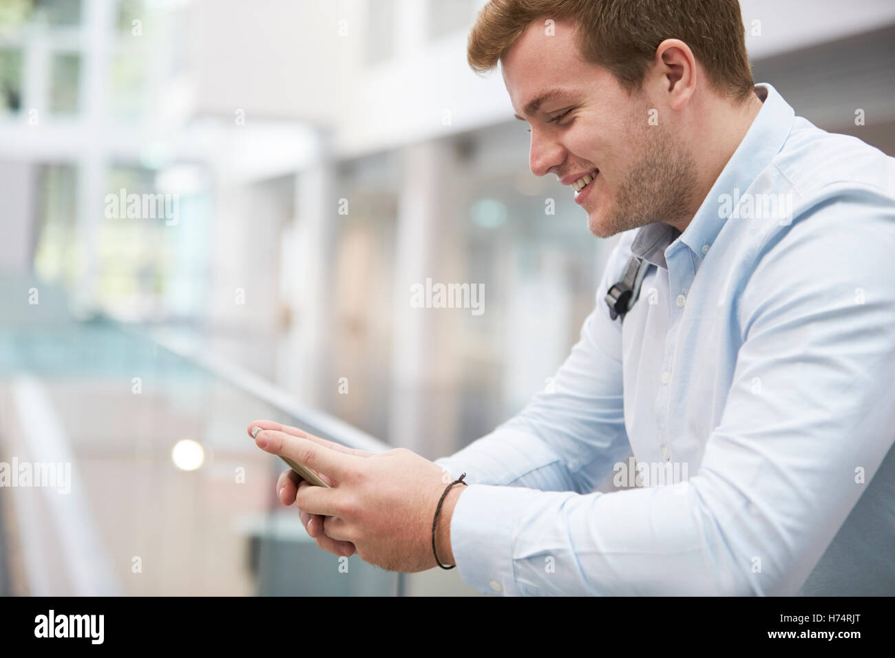 Erwachsenen männlichen Studenten mit Smartphone in Universität, Nahaufnahme Stockfoto