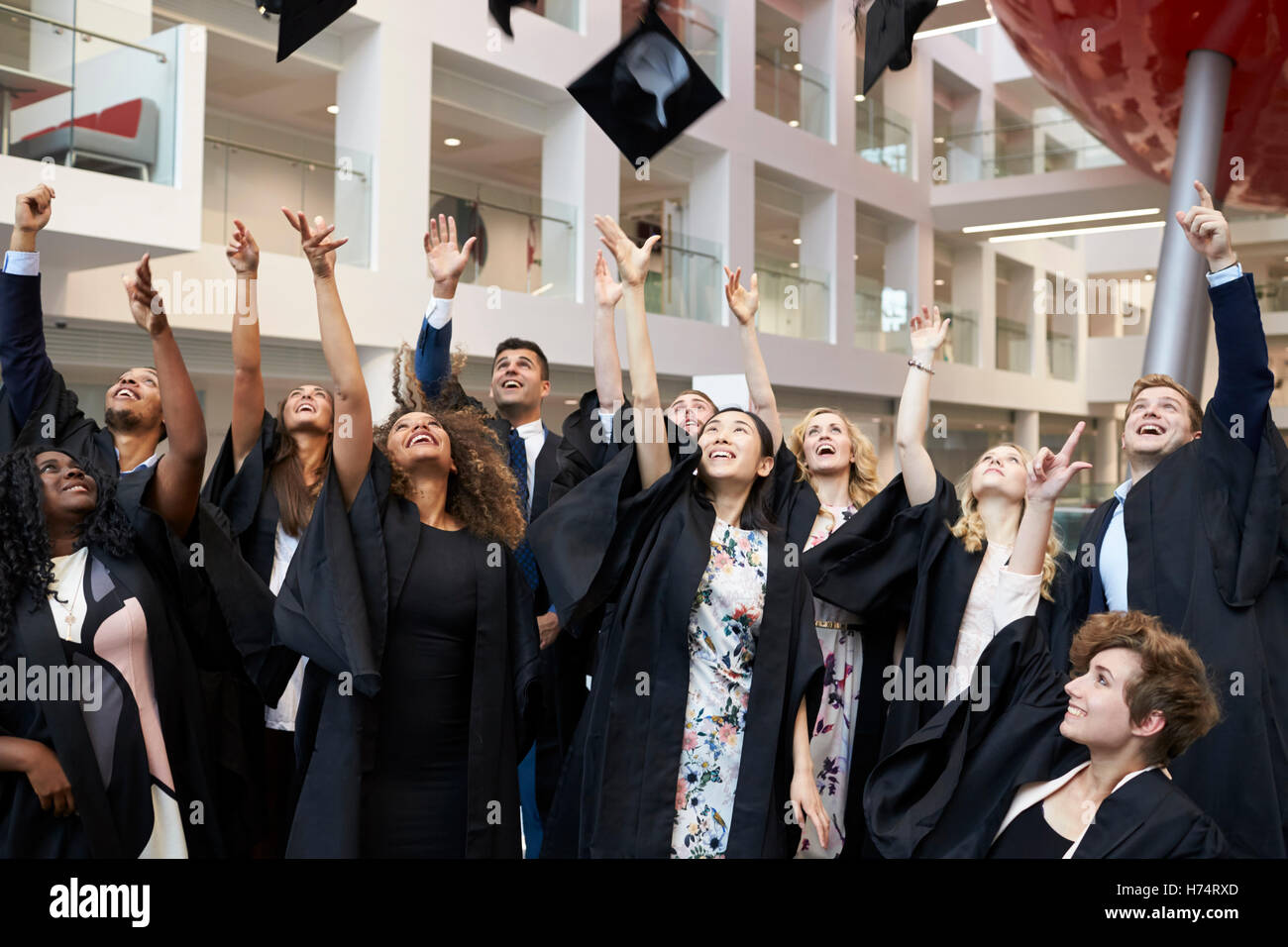 Studenten, die ihre Mützen in die Luft zu werfen, am Abschlusstag Stockfoto