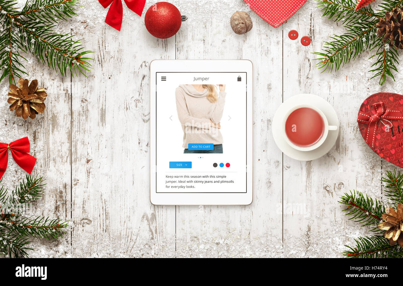 Online-shopping mit Tablet in der Weihnachtszeit Verkauf. Draufsicht der Tabelle mit Weihnachtsschmuck. Jumper auf Commerce Webs zu kaufen Stockfoto