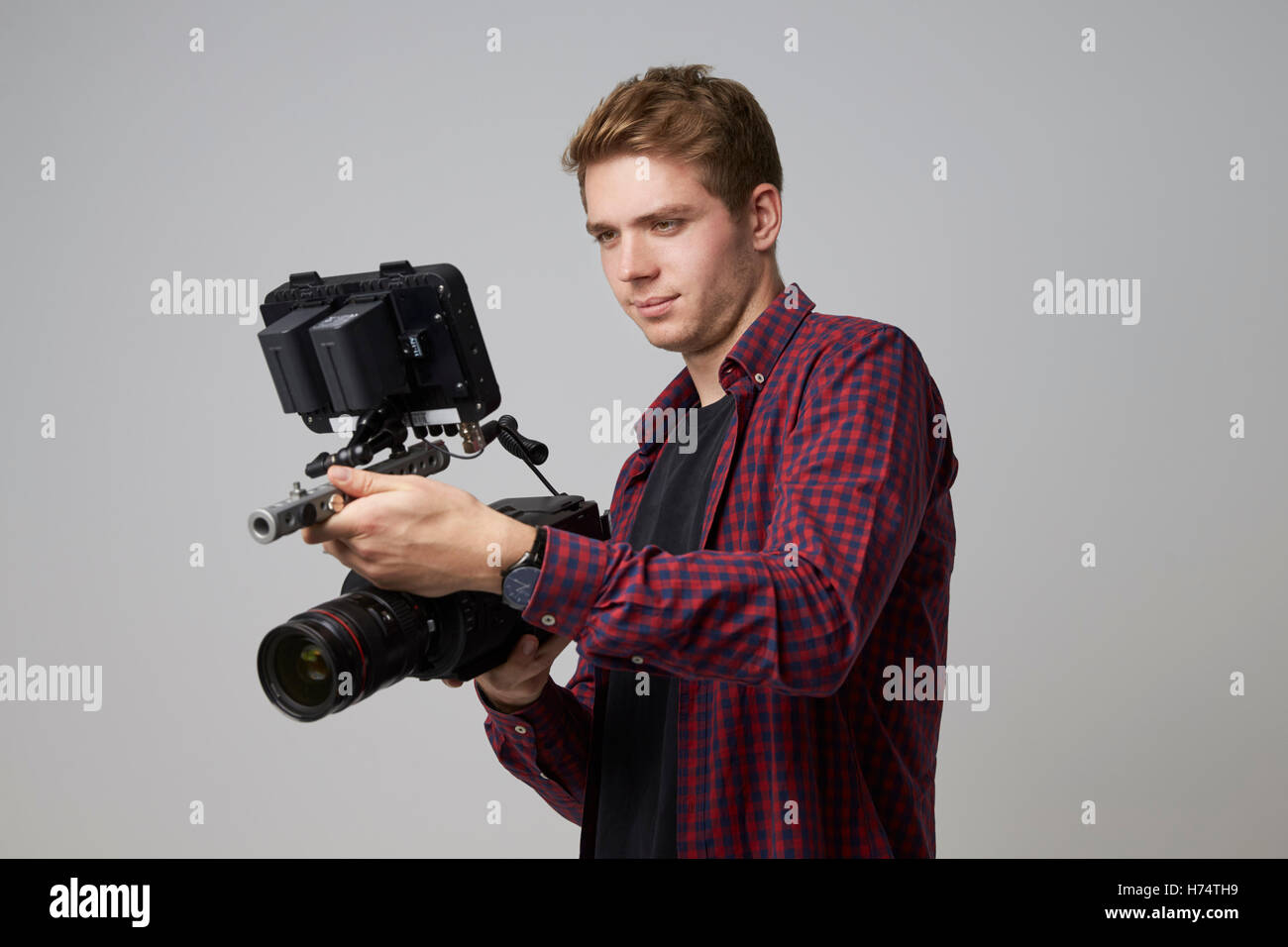Studioportrait von männlichen Videofilmer mit Filmkamera Stockfoto