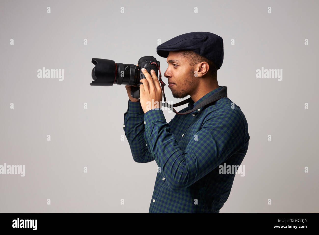 Studio-Porträt des männlichen Fotografen mit Kamera Stockfoto