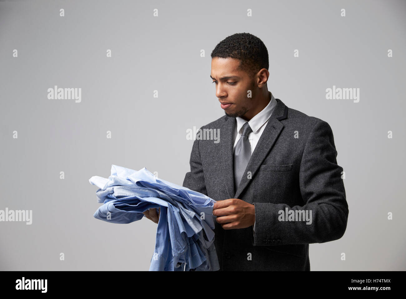 Studio-Porträt der männlichen Mode Käufer Blick auf Shirts Stockfoto