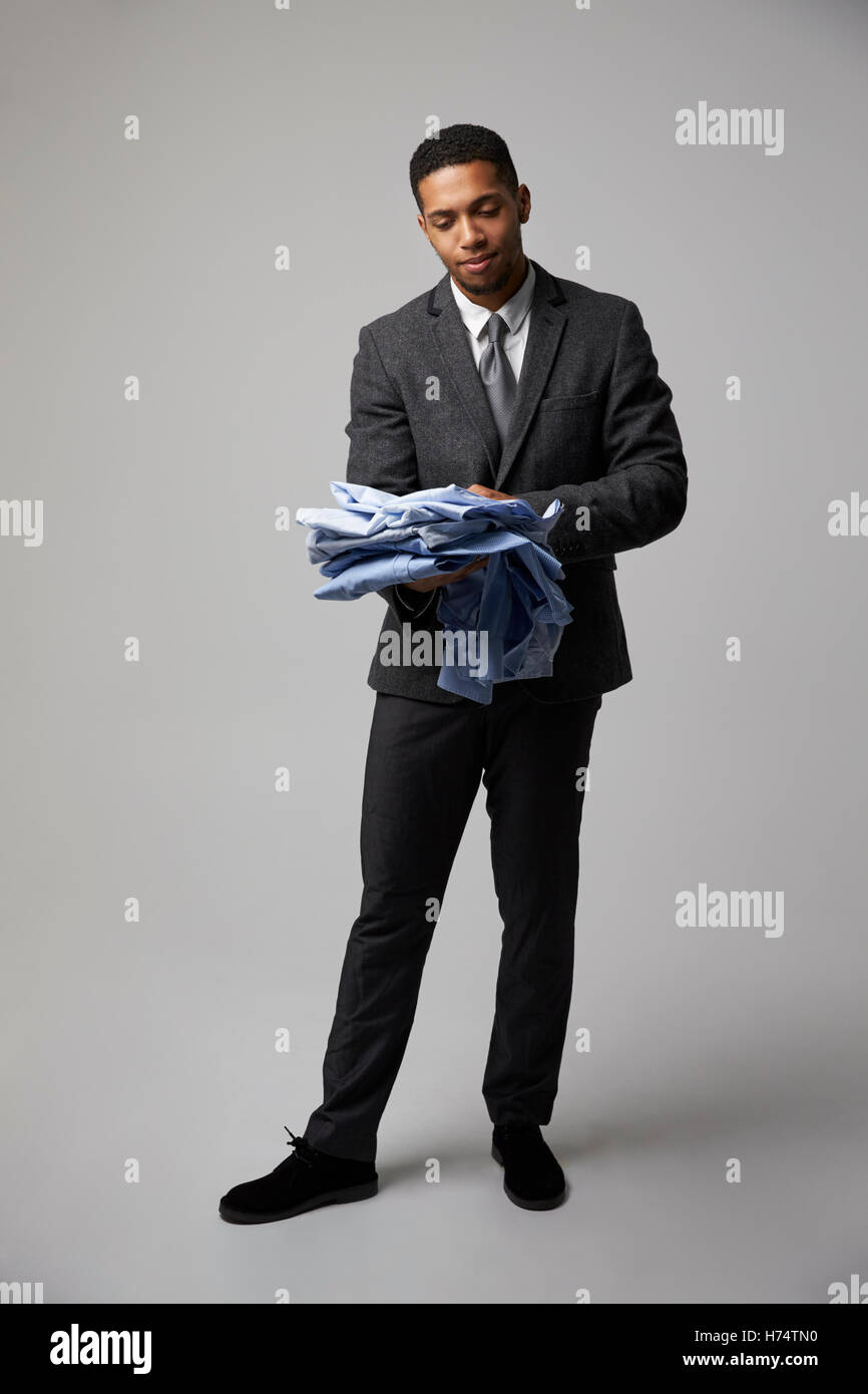 Studio-Porträt der männlichen Mode Käufer Blick auf Shirts Stockfoto
