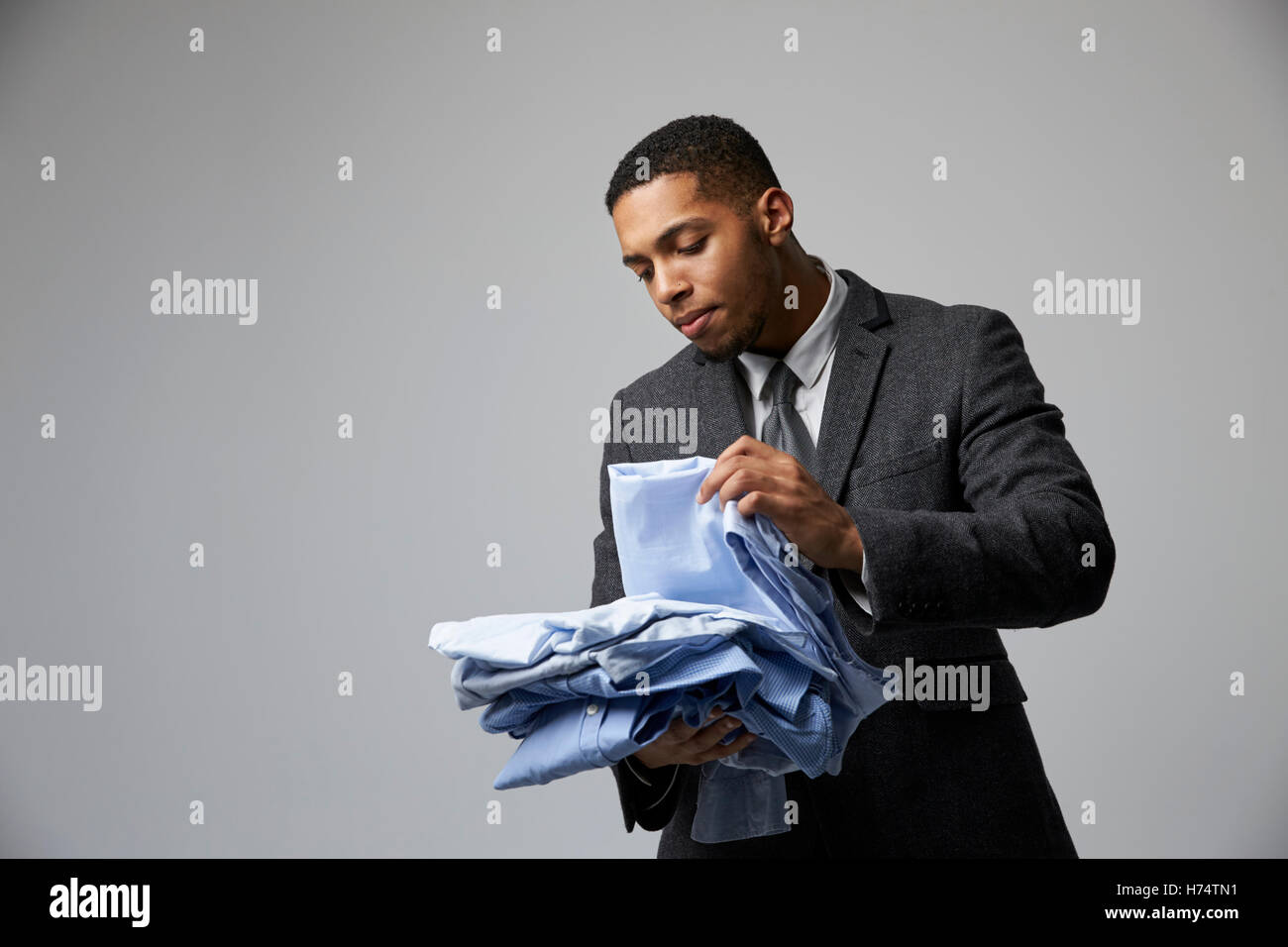 Studio-Porträt der männlichen Mode Käufer Blick auf Shirts Stockfoto