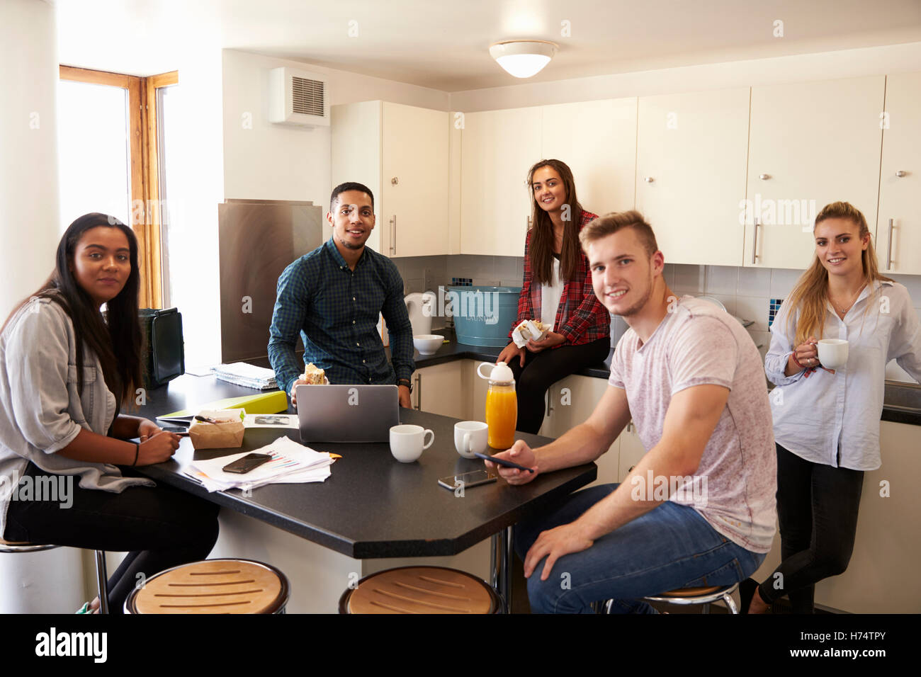 Porträt von Studenten entspannend In Küche der Unterkunft Stockfoto