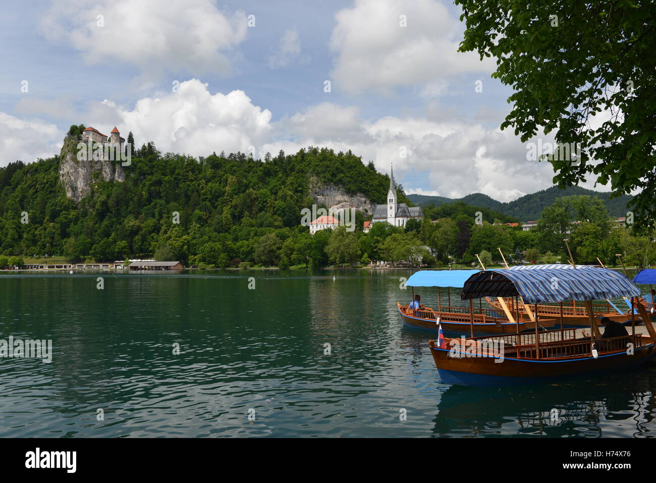 Blick über den See von Bled mit Pletna Boote Stockfoto
