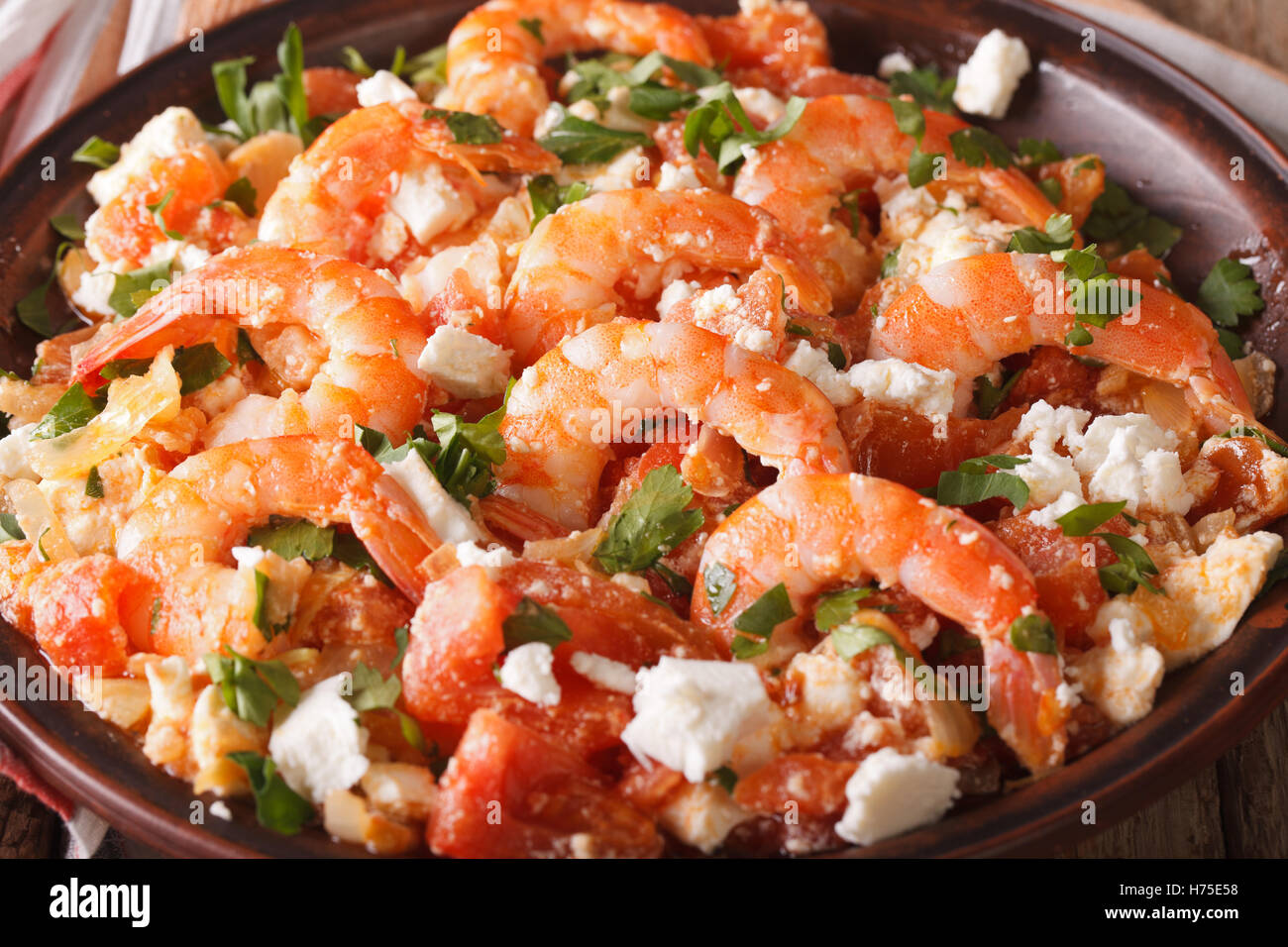 Saganaki Garnelen mit Feta-Käse und Tomaten-Nahaufnahme auf einer Platte. horizontale Stockfoto