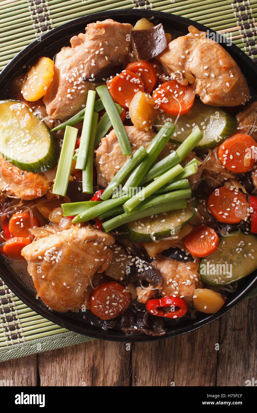 Koreanische Küche Dakjim: Huhn mit Gemüse und Sesam Nahaufnahme auf einer Platte. vertikale Ansicht von oben Stockfoto