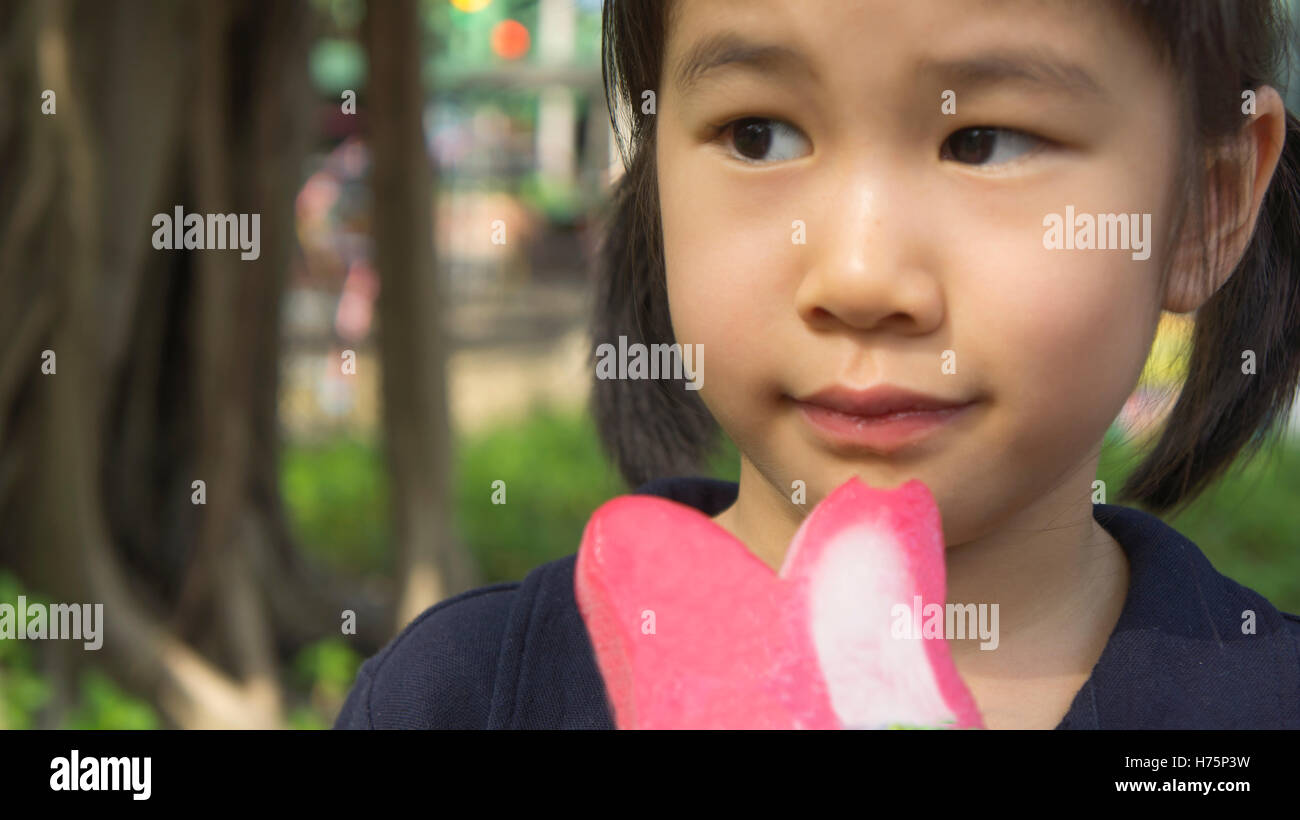 Mädchen glücklich genießen entspannen Geschmack lecken Kind Kinder junge Eis essen Stockfoto