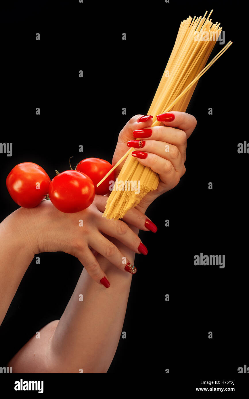 Weibliche Hände mit schönen Maniküre zu halten, Spaghetti und Tomaten Stockfoto