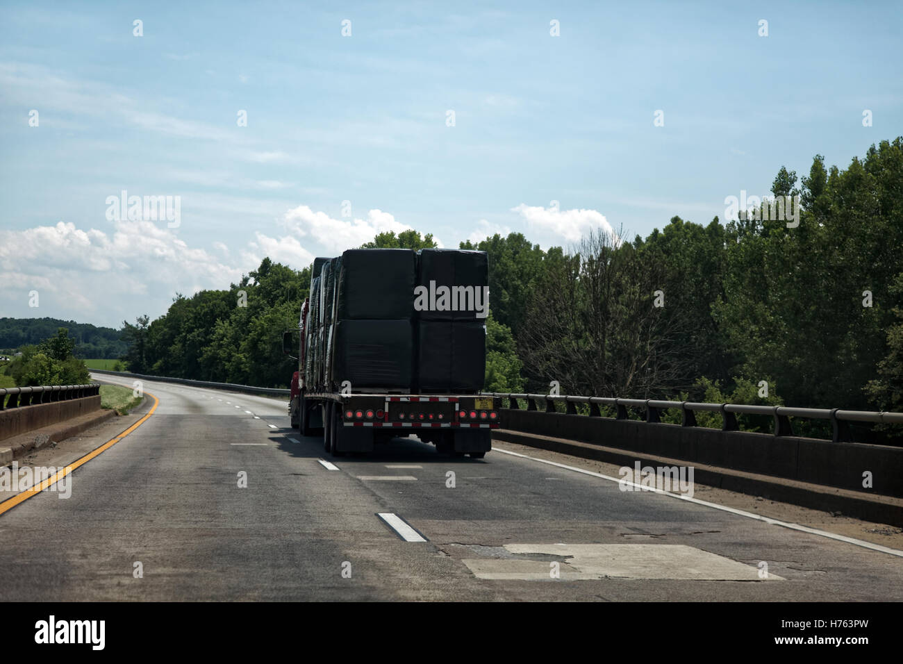 Sattelauflieger bedeckt in schwarzen Falle schleppen Fracht auf der Autobahn Stockfoto