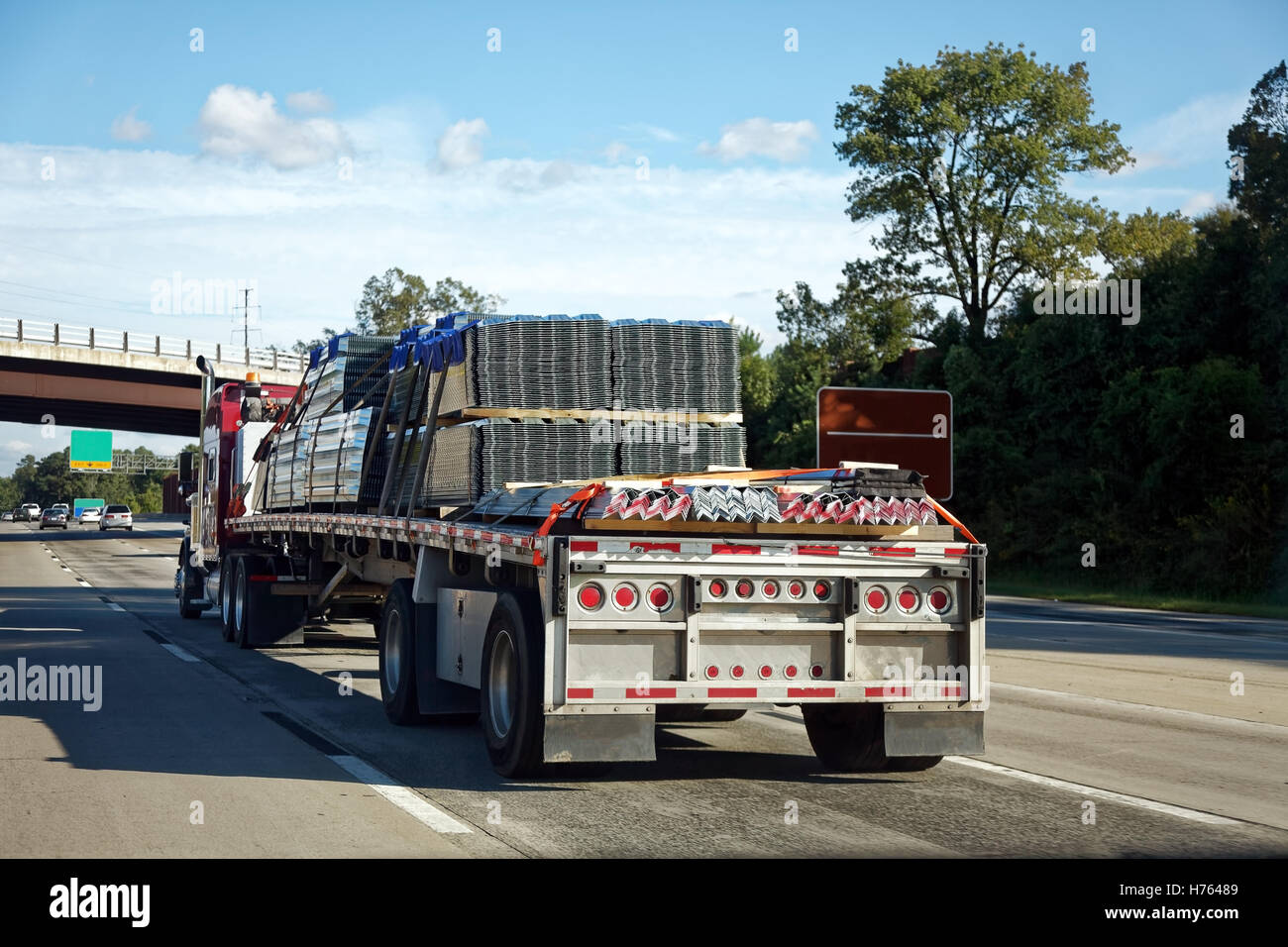 Rückansicht des Flachbett-halb schleppen Bau Fracht auf der Autobahn Stockfoto