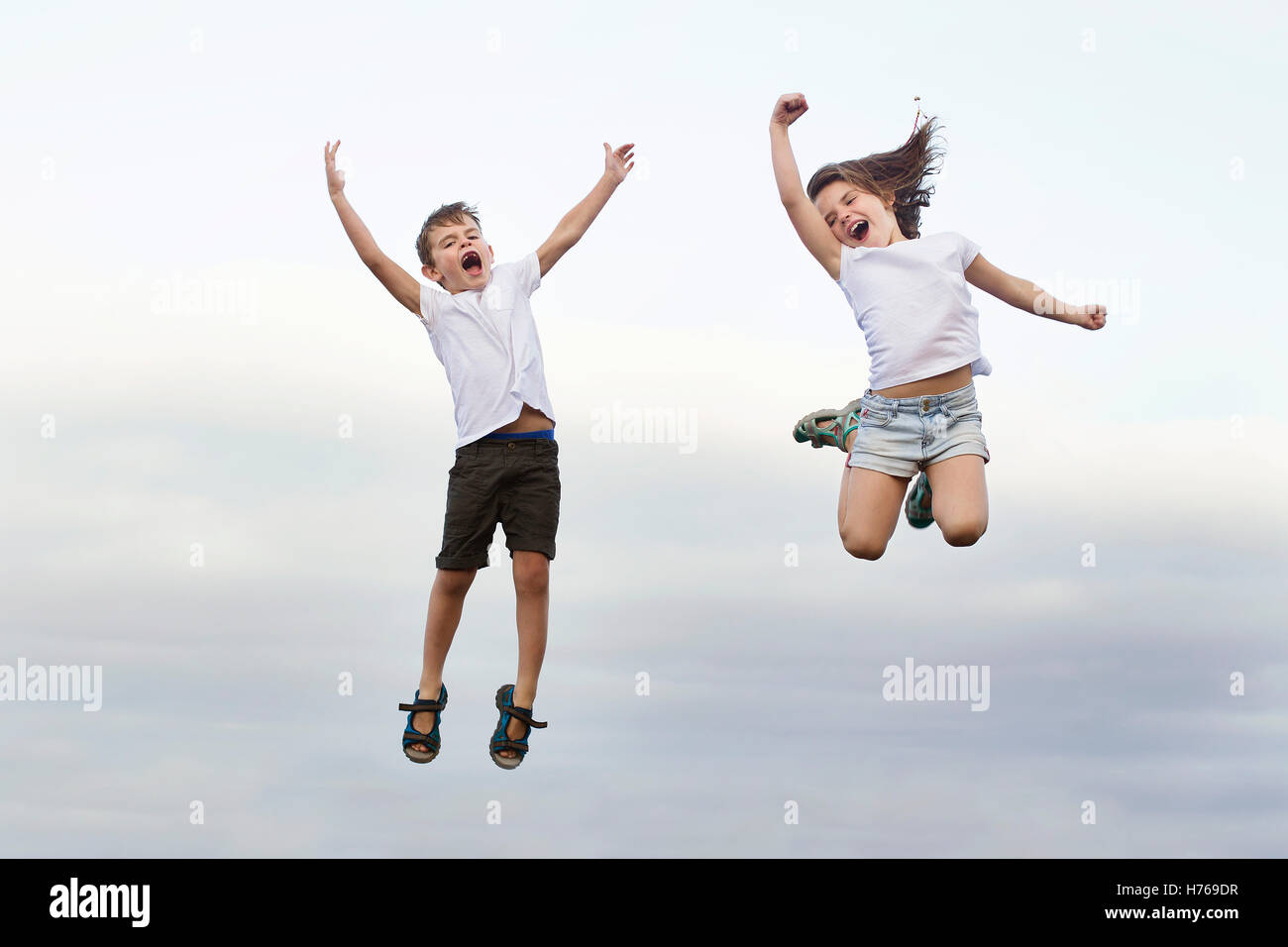 Jungen und Mädchen in die Luft springen und schreien Stockfoto