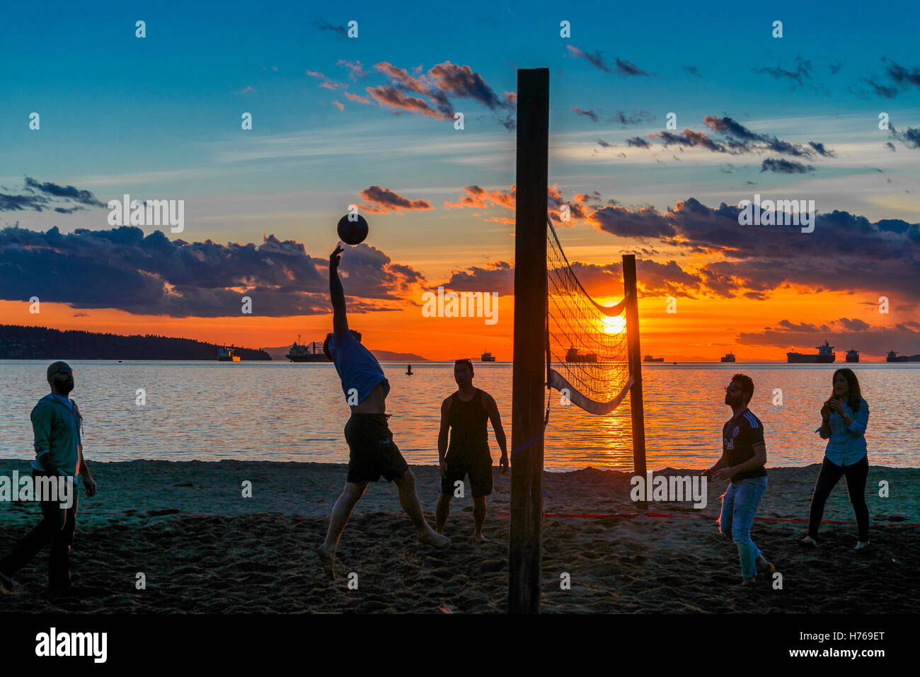 Eine Partie Beach-Volleyball bei Sonnenuntergang, Englisch Bay Beach, Vancouver, Britisch-Kolumbien, Kanada Stockfoto