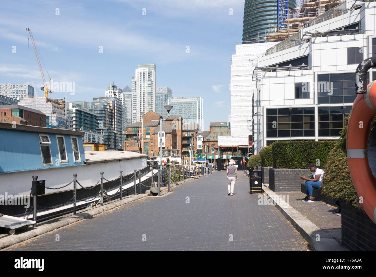 LONDON, Vereinigtes Königreich - 24. August 2016: Stadtarbeiter entspannt entlang dem Dock von Oakland Quay in Crossharbour. Stockfoto