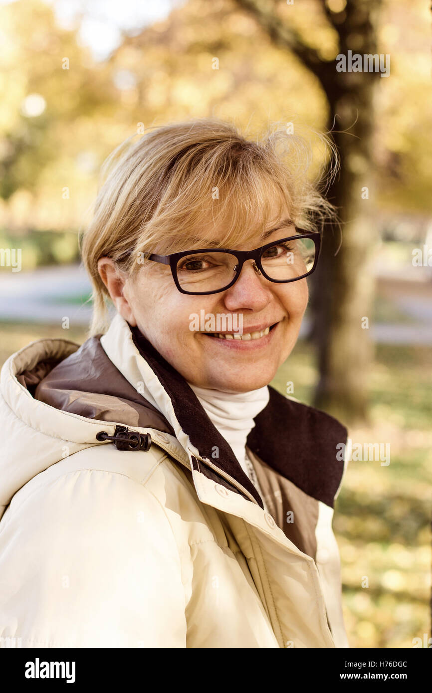 Niedliche Reife Frau mit Brille im Herbst park Stockfoto