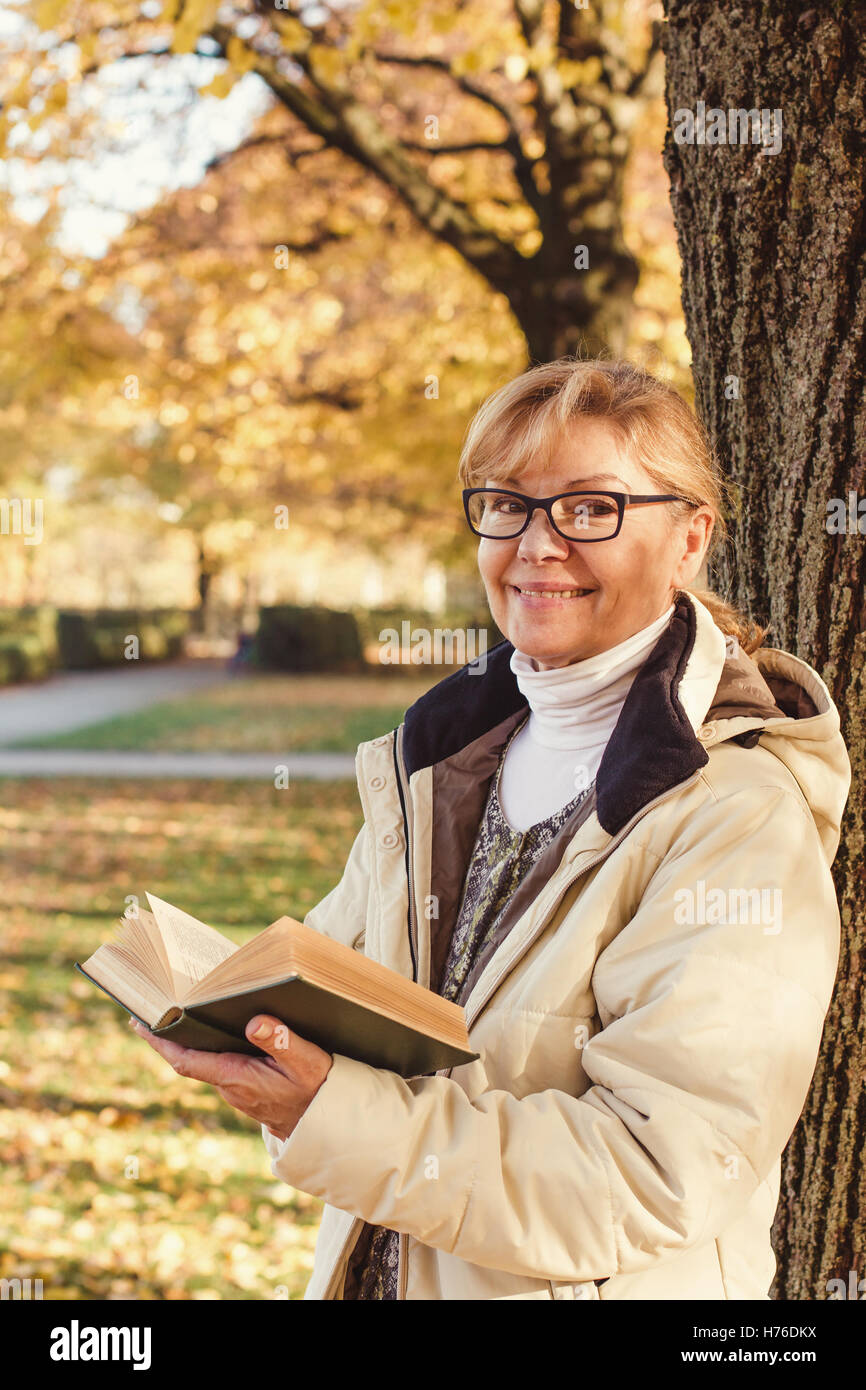 Niedliche Reife Frau mit Brille im Herbst park Stockfoto
