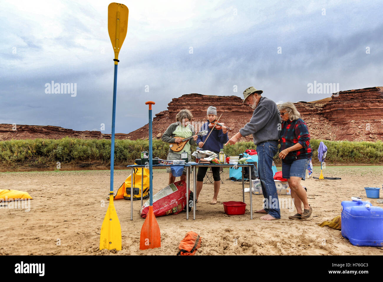 Eine mehr-Generationen-Familie kocht und spielt Musik an einem Strand auf dem Green River in Canyonlands National Park, Utah. Stockfoto