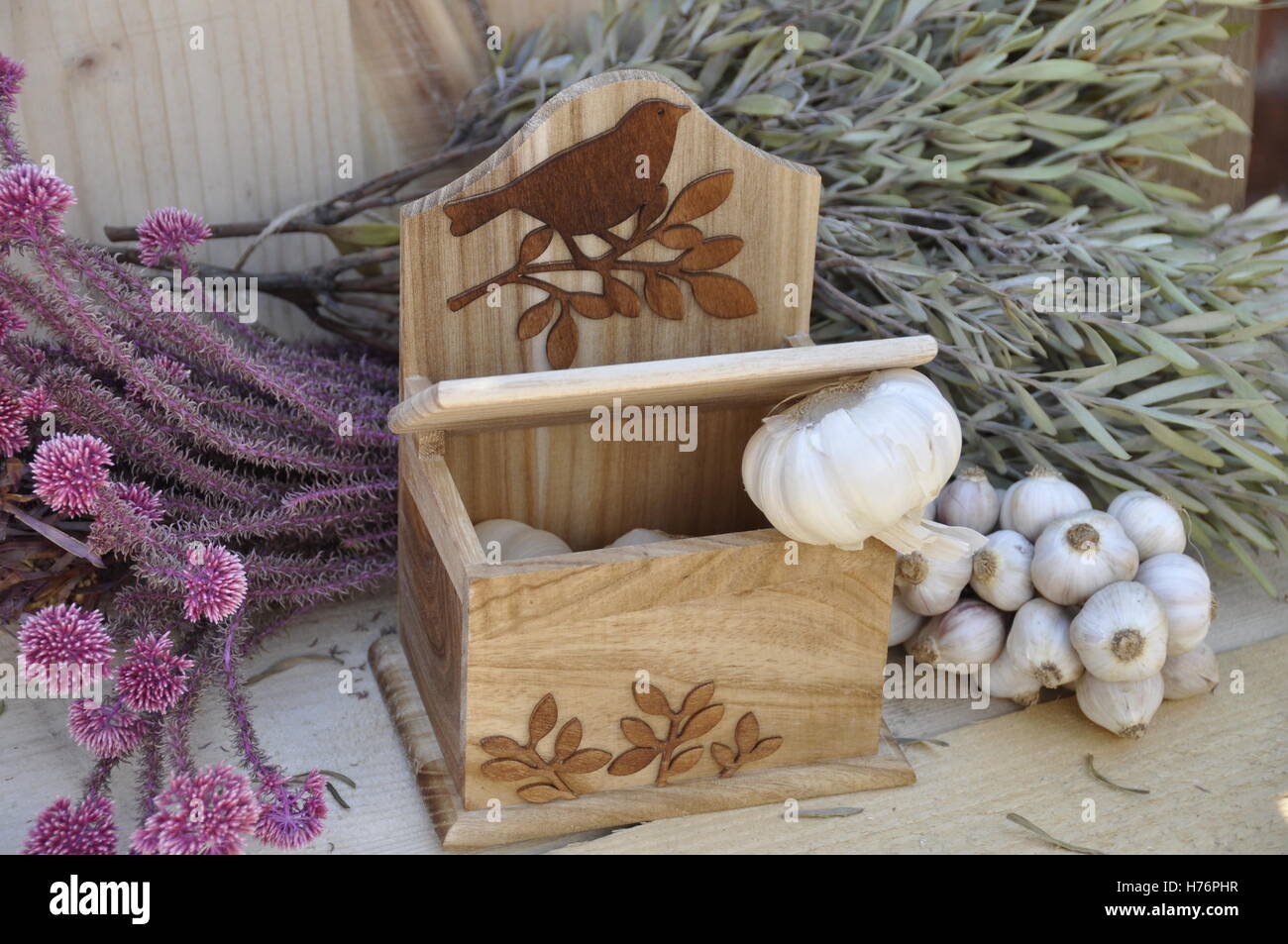 Holzsalzbox mit Knoblauch und getrockneten Blumen Stockfoto