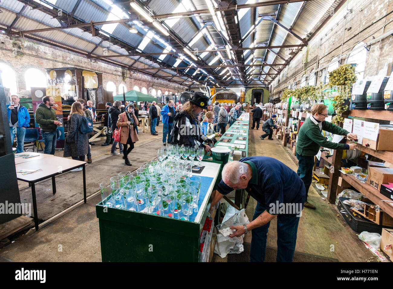 CAMRA Bierfestival in alten Lokomotive in Tunbridge Wells, Großbritannien beleuchten. Menschen Auswahl Biere aus verschiedenen Fässer, Bierfässer, hinter einer langen Tresen. Stockfoto