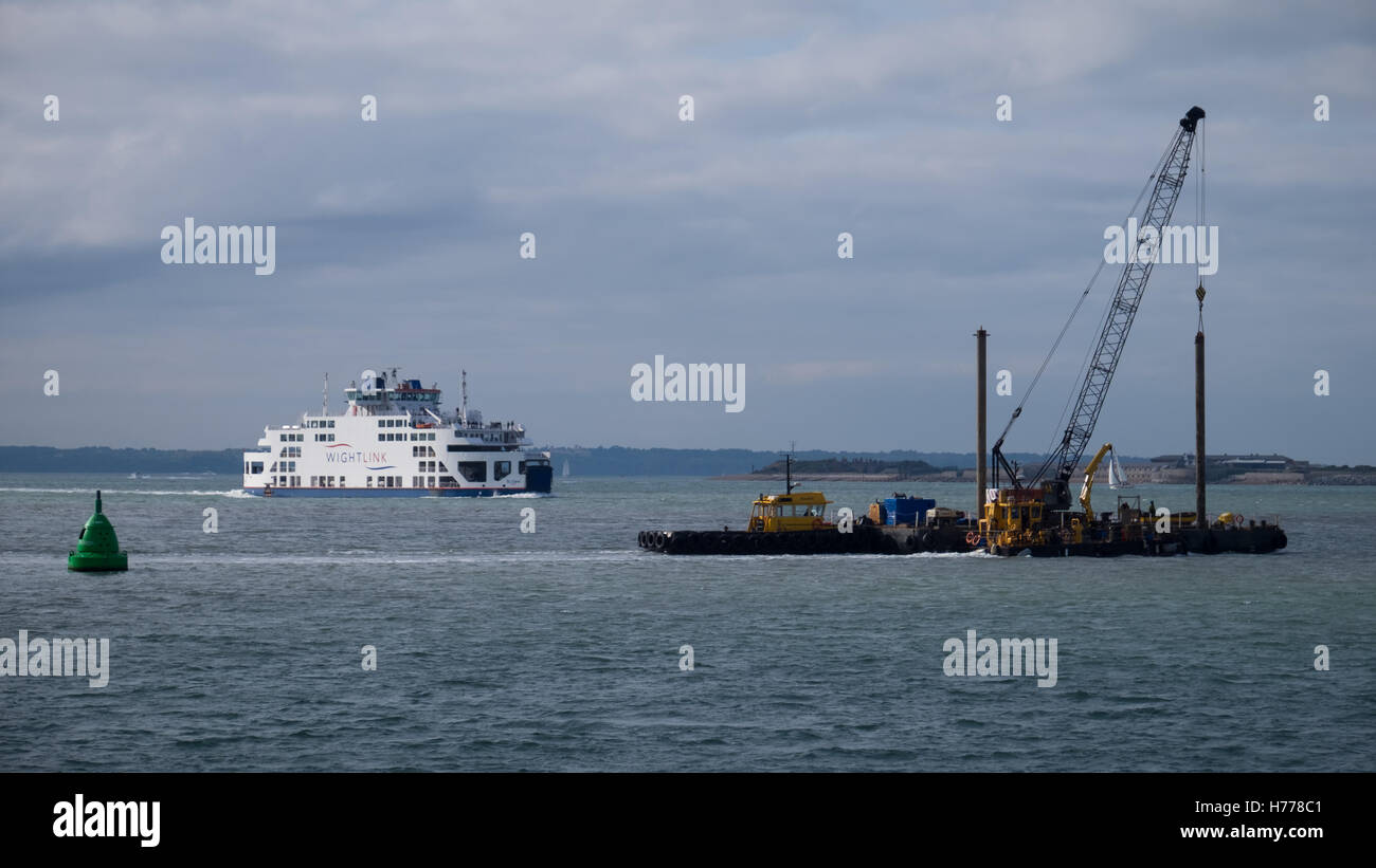 Eine Wightlink Autofähre und ein lastkahn Navigieren im Kanal Ansätze für Portsmouth Harbour in den Solent Stockfoto