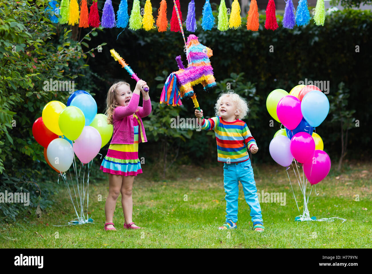 Kinder-Geburtstags-Party. Gruppe von Kindern Pinata schlagen und spielen  mit Luftballons. Familie mit Kindern feiern Geburtstag im Garten  Stockfotografie - Alamy