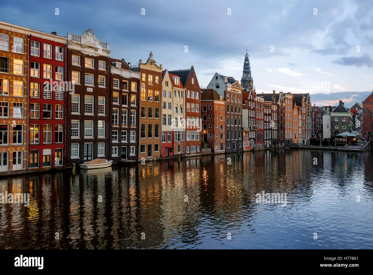 Tanz der Häuser auf dem Damrak und Oudekerksplein Tower, Amsterdam, Niederlande Stockfoto