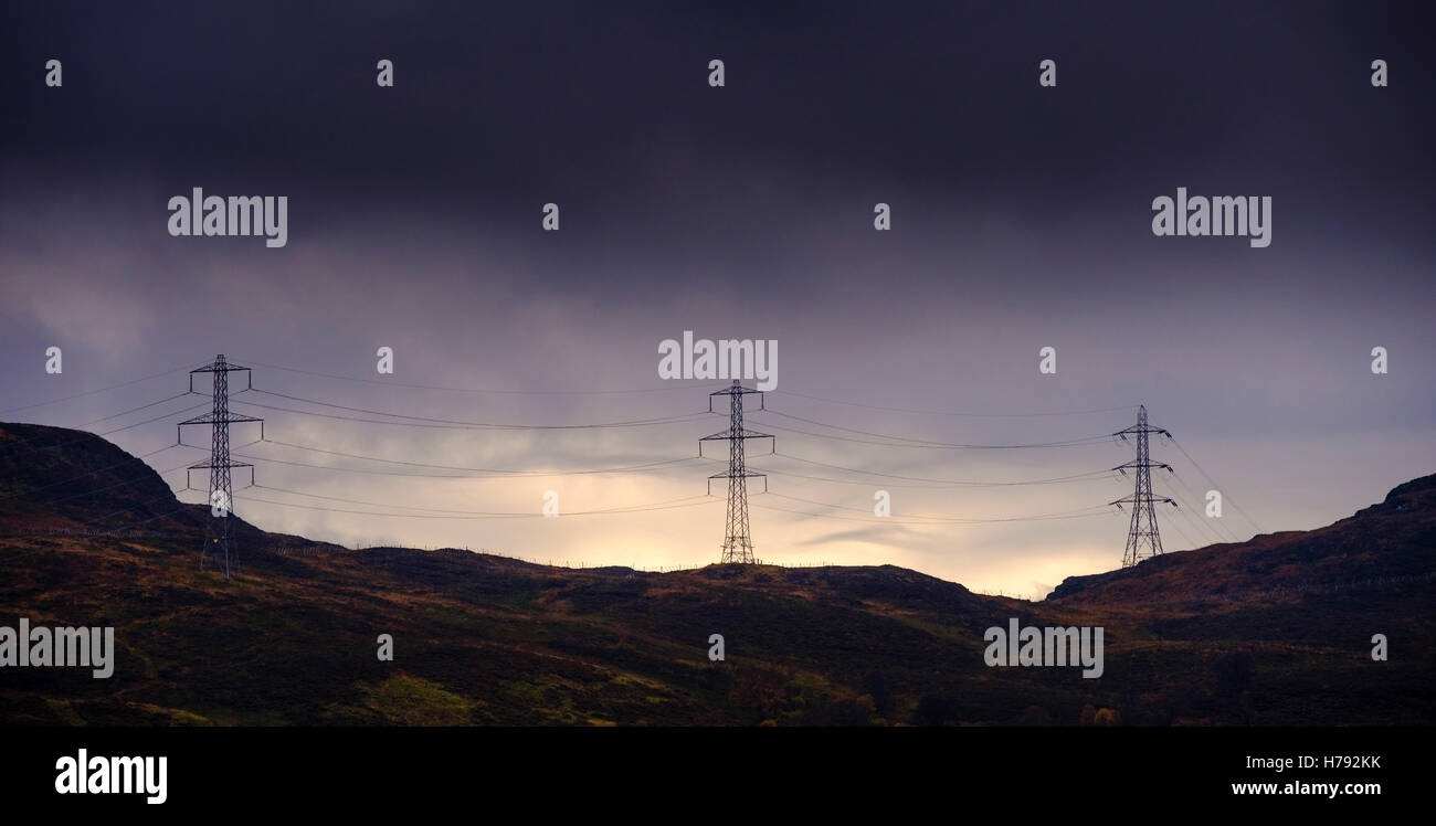 Strommasten überqueren die Berge hoch über Loch Arklet, Loch Lomond & The Trossachs National Park, Schottland Stockfoto