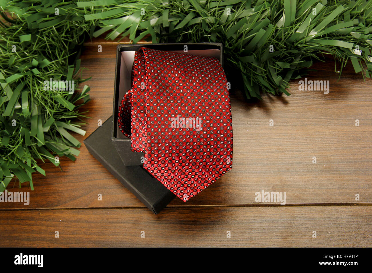 Rote Krawatte und Box auf Holz mit einer Dekoration gerollt Stockfoto