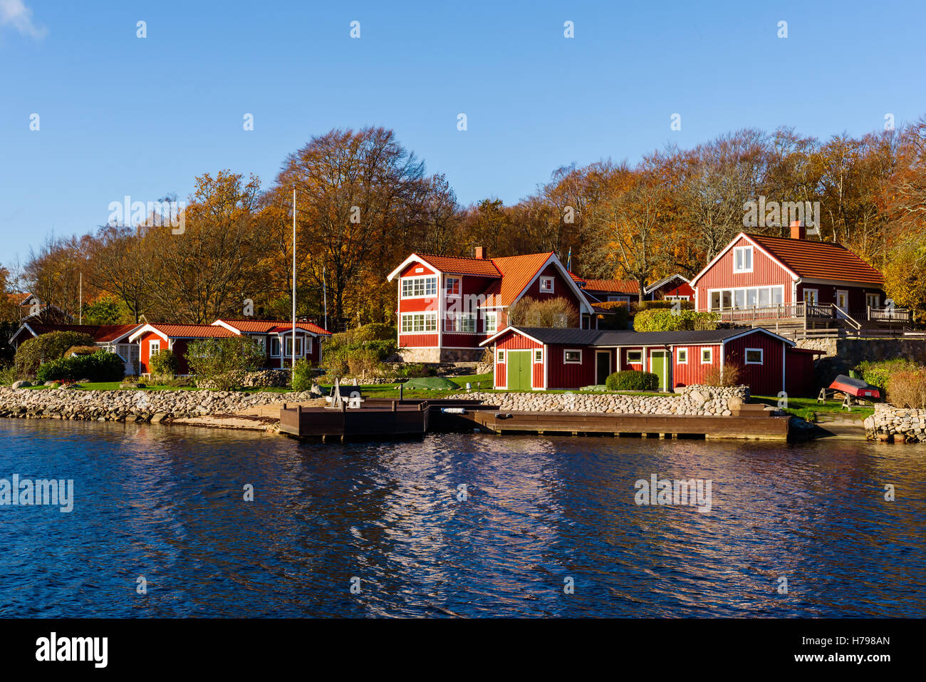 Bokevik, Schweden - 29. Oktober 2016: Ökologische Dokumentation der küstennahen Lebensweise. Häuser der roten Holz am Meer mit privaten Stegen Stockfoto